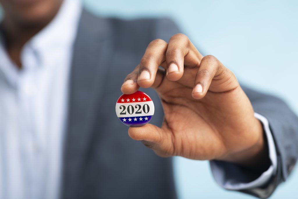 Businessman holding Vote button for Presidential election 2020